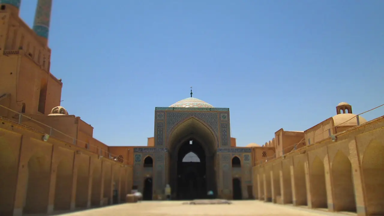 حیاط مسجد جامع یزد با ایوان کاشی‌کاری‌شده، گنبد فیروزه‌ای و رواق‌های دو طرف
