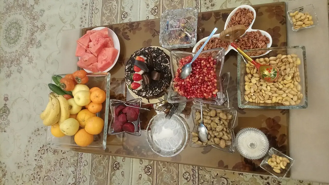 سفرهی شب یلدا با انار دانهشده، هندوانه، آجیل، میوه و شیرینی