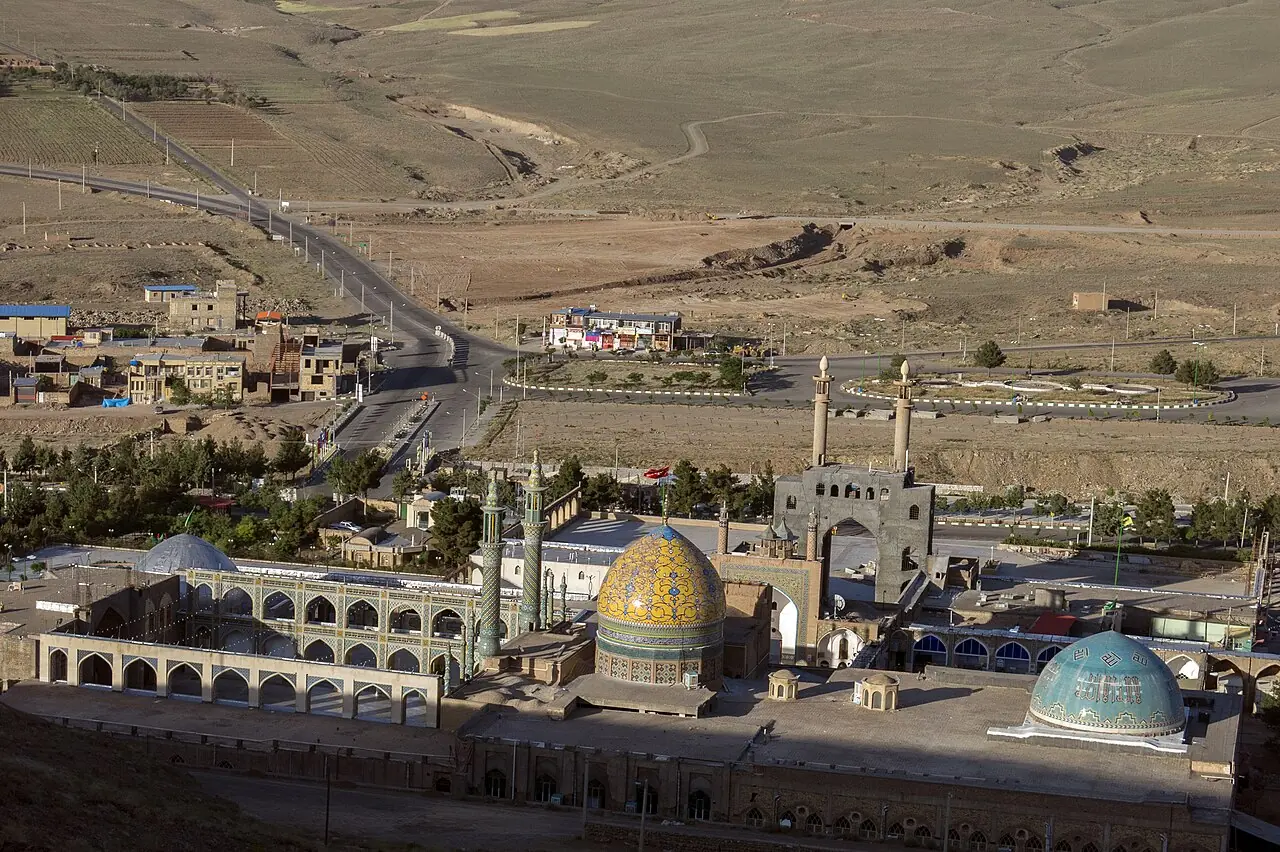 نمای بالا از مجموعه‌ی امامزاده سلطان‌علی، روستای مشهد اردهال و جاده‌ای که از دشت می‌گذرد