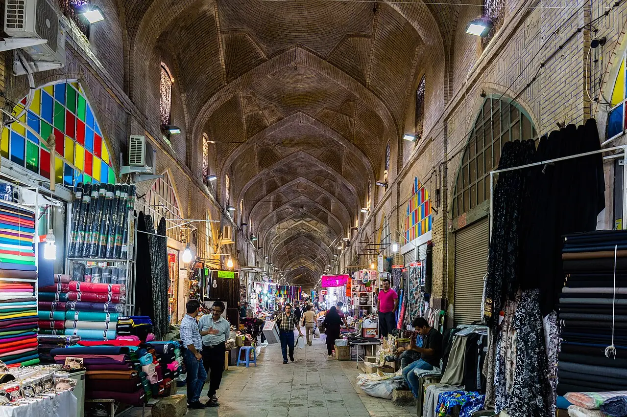 راسته‌ی سرپوشیده‌ی بازار وکیل با طاق‌های آجری و مغازه‌های پارچه‌فروشی در دو طرف